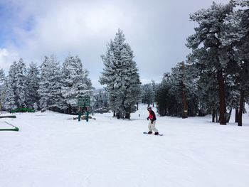 Person skateboarding on snow covered field