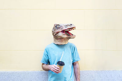 Man wearing hat standing against wall