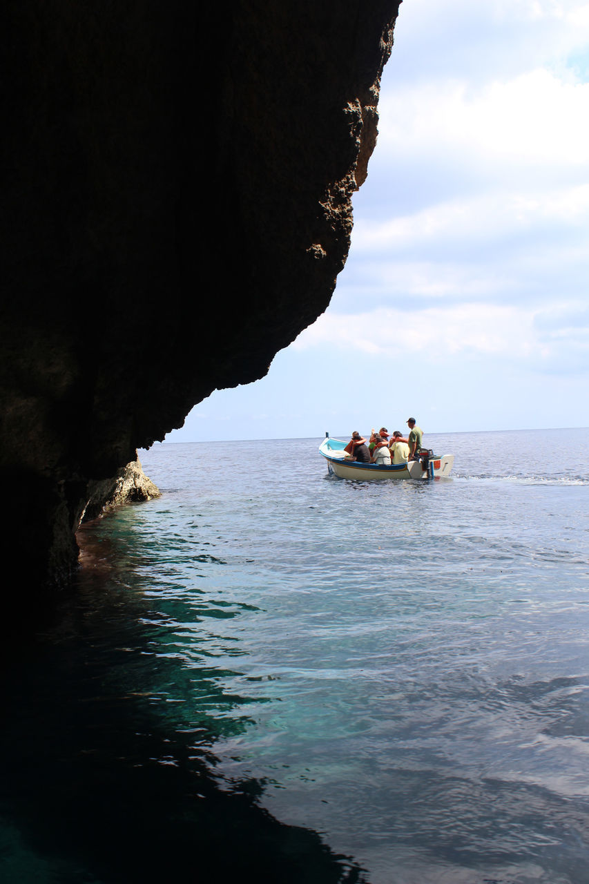 PEOPLE ON BOAT AGAINST SEA