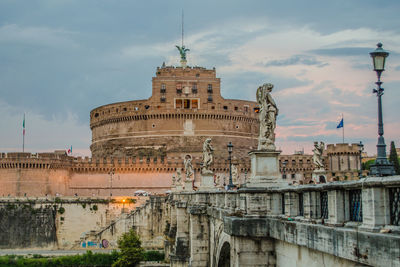 Castel sant angelo and ponte sant angelo against sky during sunset in city