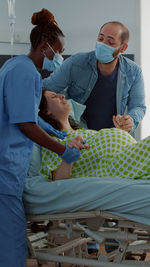 Rear view of doctor examining patient at home