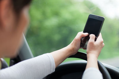 Close-up of woman using phone in car