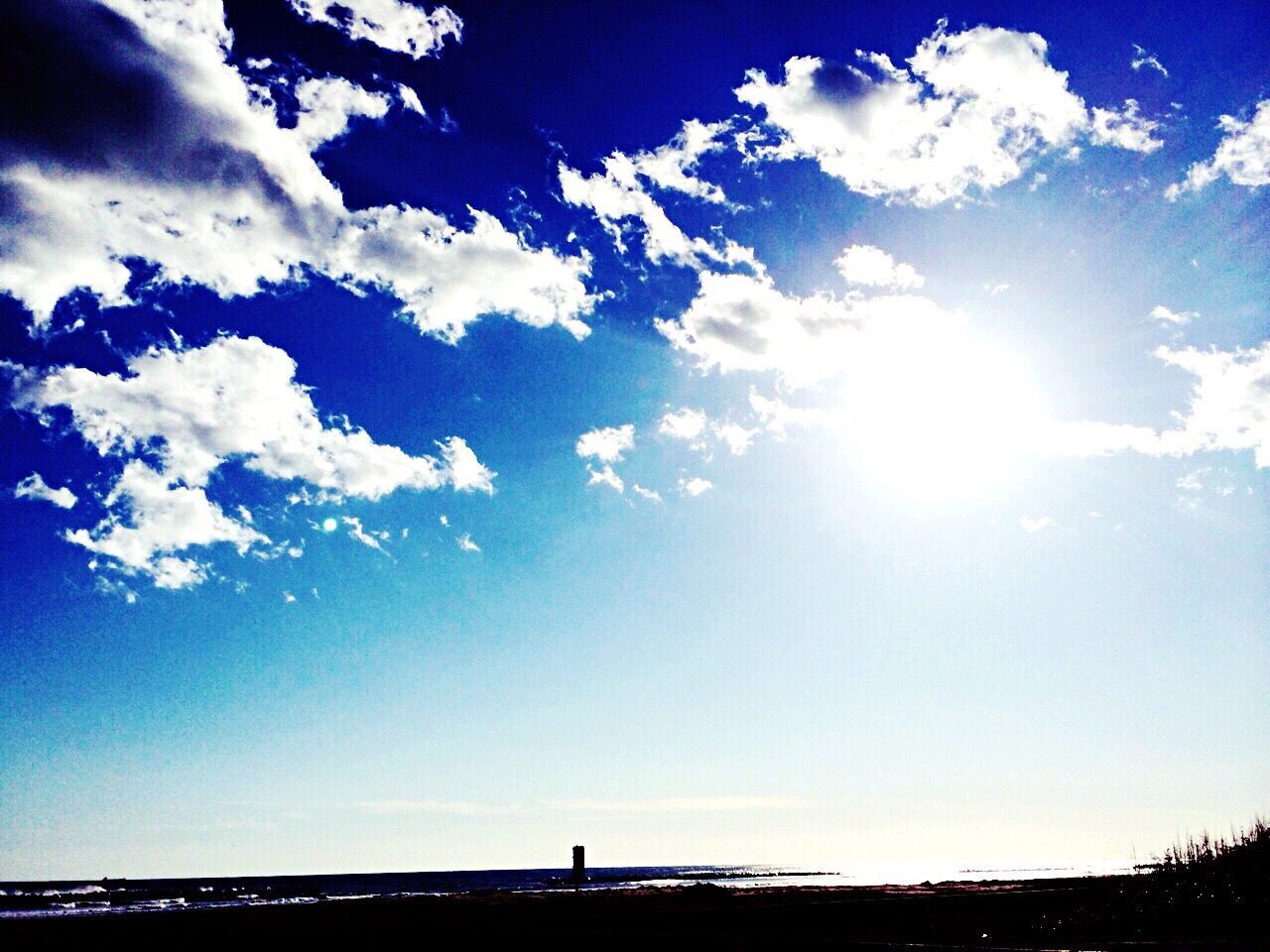 silhouette, sky, sun, tranquility, tranquil scene, beauty in nature, sunlight, scenics, water, sunbeam, blue, cloud - sky, nature, sea, idyllic, cloud, horizon over water, outdoors, lens flare