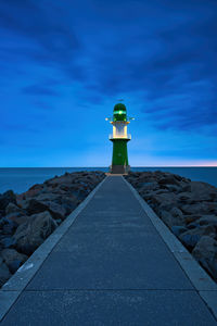 Lighthouse by sea against sky