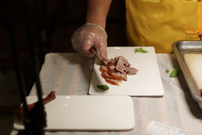 Midsection of man preparing food on cutting board