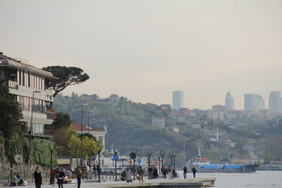 Group of people on beach against buildings in city