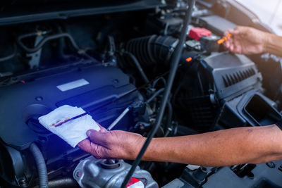 Midsection of man repairing car engine