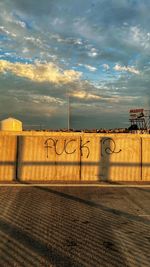 Text on wall against sky