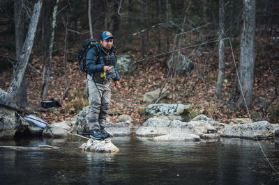 A man fly-fishes during a fall morning on a maine river