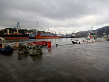 Boats moored at harbor against sky