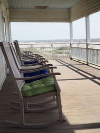 Empty rocking chairs in row on porch