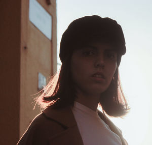 Portrait of young woman against wall