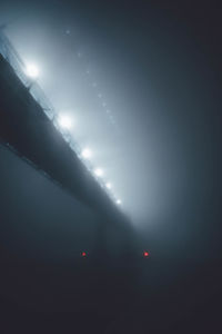 Defocused image of illuminated lights against sky at night