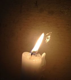 Close-up of lit candle in dark room