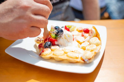 Bubble waffles with ice cream and fresh fruits. strawberries, kiwi, bilberries, strawberry sauce