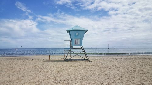 Lifeguard hut on beach against sky