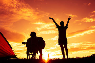 Silhouette people standing against sky during sunset