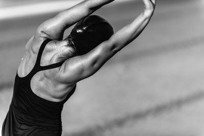 Woman in swimwear stretching hands