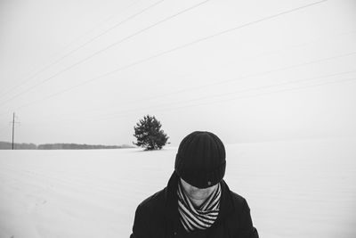 Rear view of man in snow against clear sky