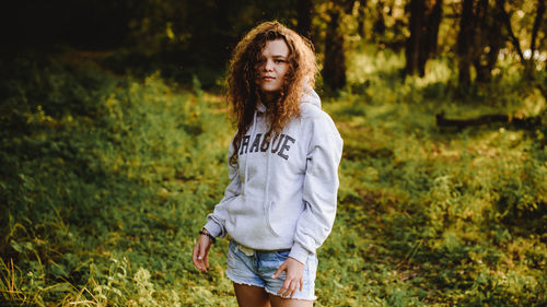 Portrait of smiling young woman standing in forest