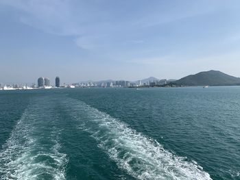 Scenic view of sea by city against sky