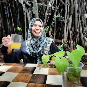 Cheerful woman having drink at outdoor cafe