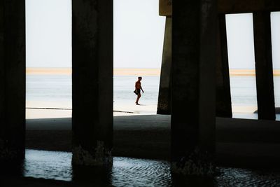 Silhouette of woman in sea at sunset