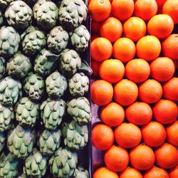 Directly above view of fresh oranges and artichokes at la boqueria