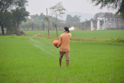 Rear view of man walking on field