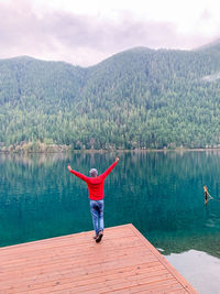 Rear view of people in lake against mountains