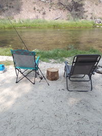 Chair on lake against landscape