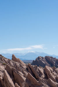 Scenic view of rocky mountains against blue sky