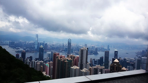 View of cityscape against cloudy sky