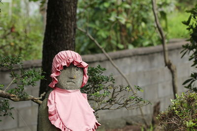 Rear view of woman with pink umbrella against trees