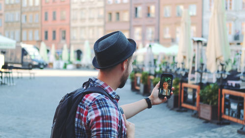 Portrait of man using mobile phone in city