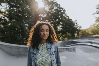 Smiling teenage girl looking at skate park looking at camera