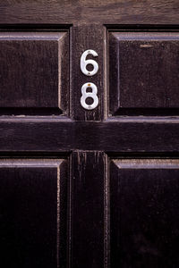 House number 68 on a dark wooden front door in london 