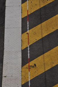 High angle view of chain on striped road marking