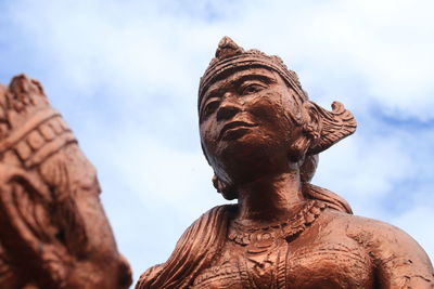Low angle view of angel statue against cloudy sky