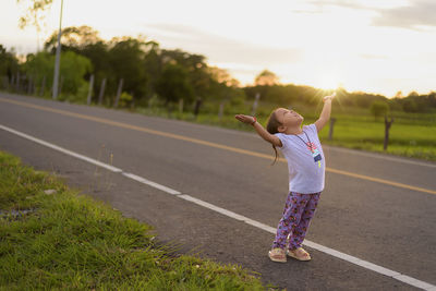 Rear view of woman walking on road