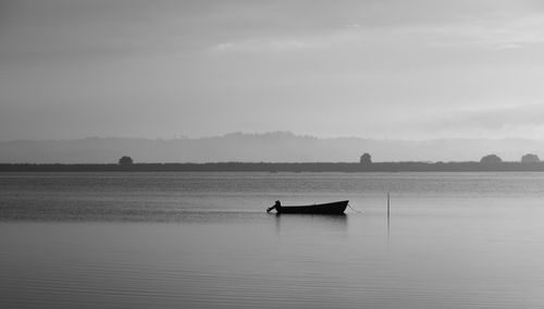 Silhouette man in sea against sky