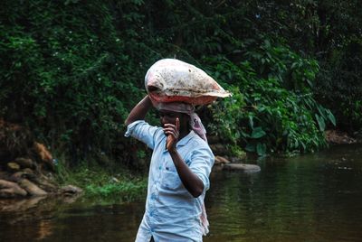 Men holding sandbag on river 