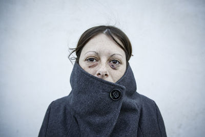 Portrait of woman standing against wall