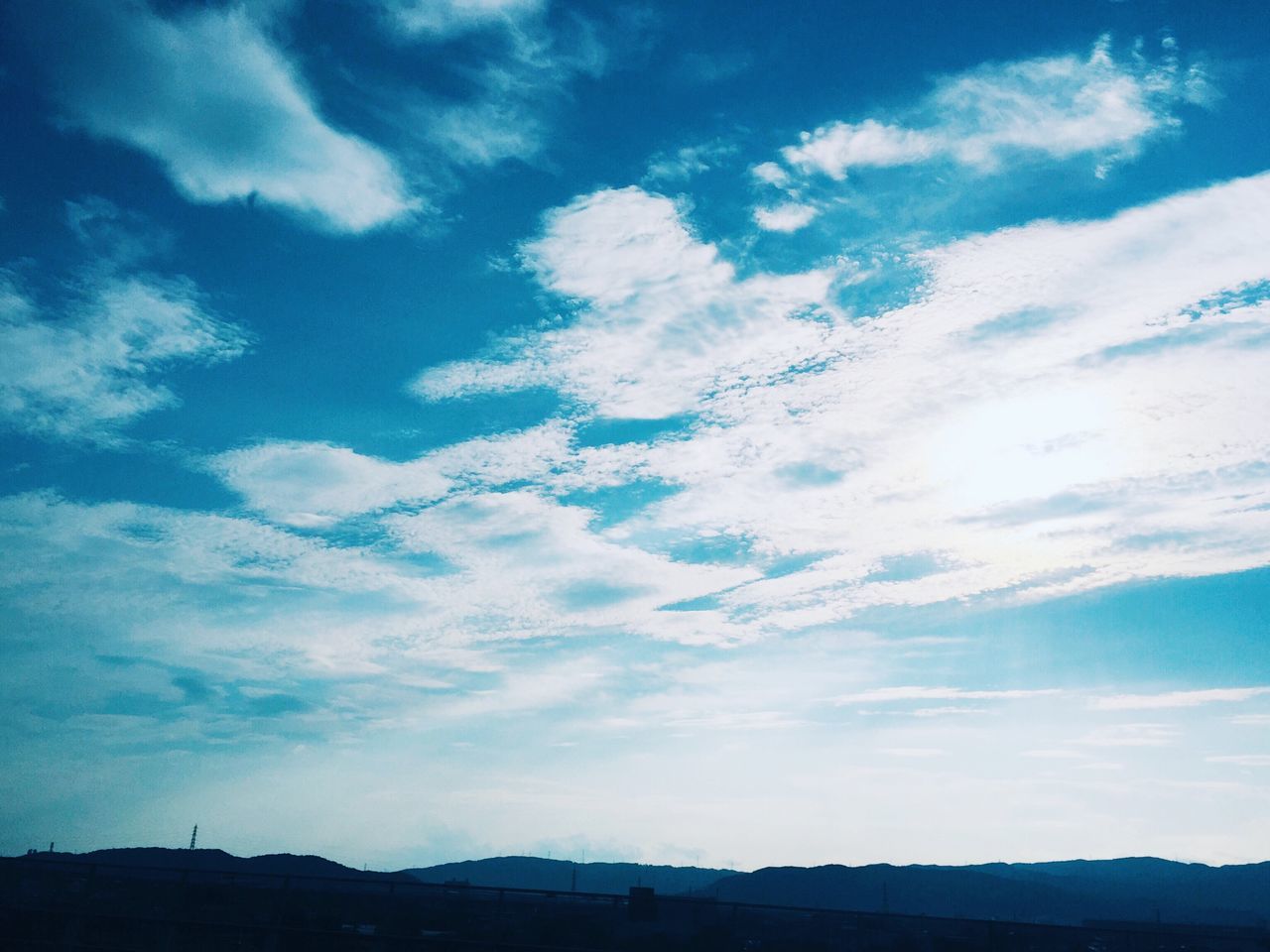 sky, cloud - sky, blue, cloud, scenics, tranquility, beauty in nature, tranquil scene, nature, landscape, cloudy, outdoors, no people, mountain, idyllic, day, cloudscape, horizon over land, non-urban scene, dark, weather