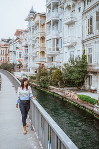 Rear view of woman standing in canal