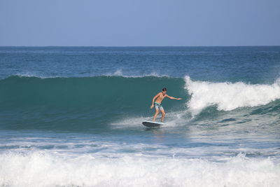 Man surfing in sea against sky