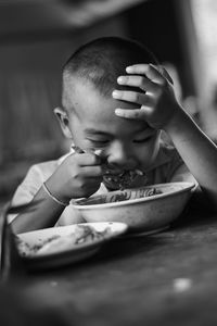 Close-up of cute boy eating food on table