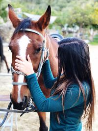 Woman standing by horse