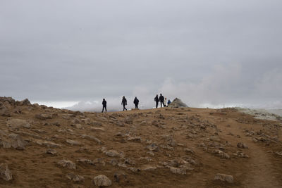 Group of people on a slope against the sky