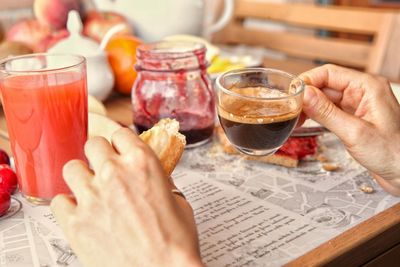 Midsection of man holding wine glasses on table